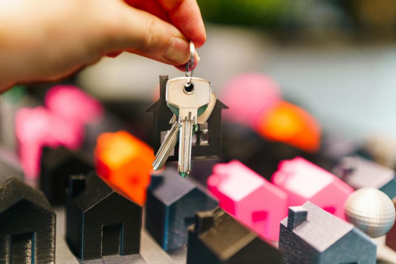 Blog 6 Colorful miniature houses and a hand holding keys