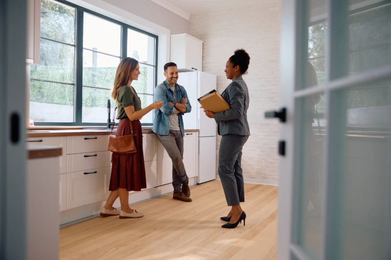 Happy couple talking with real estate agent